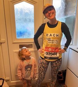 Woman posing in running gear with small child looking up at her