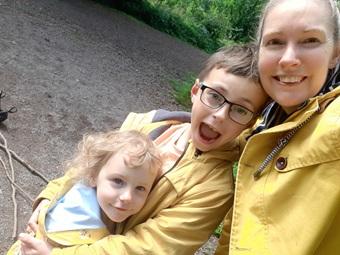 Woman with her two children. They are all wearing yellow raincoats.