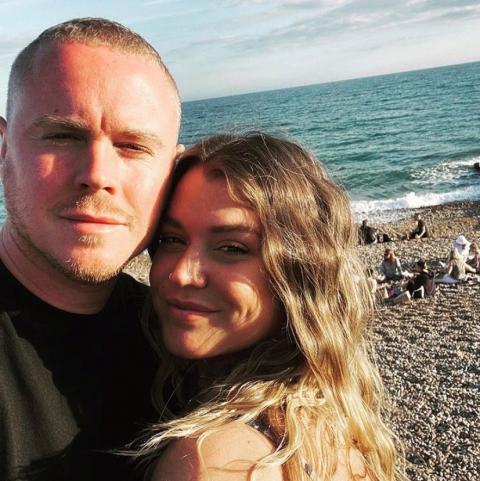 Young man and woman posing together on the beach