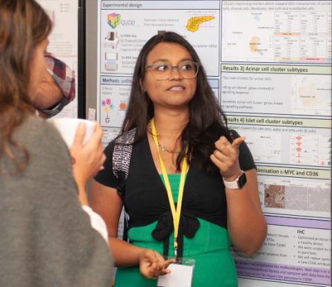 Photo of Summer student Simran talking at a conference