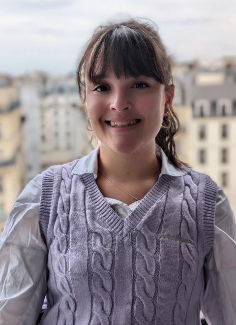 Photo of CF researcher Charlotte with buildings in the background