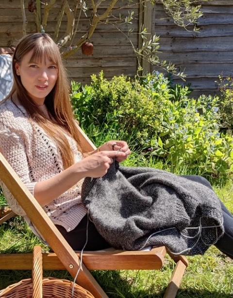 Sarah knitting in a chair
