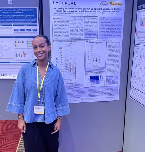 Anais at UKCFC research conference in front of her poster