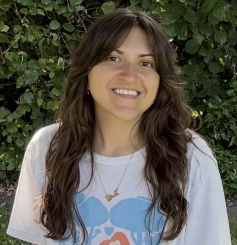 women with long dark hair smiling into camera outside