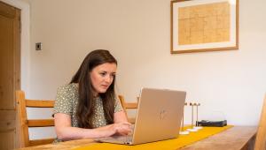 Woman in green dress uses laptop