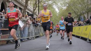 A man running, wearing a yellow Cystic Fibrosis Trust vest