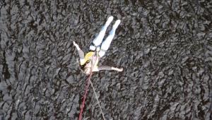 a lady in a yellow cystic fibrosis trust top doing a bungee jump