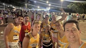 a group of 9 people wearing cystic fibrosis vests smiling in a street in vietnam