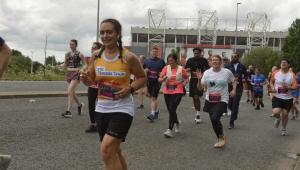 A lady running with Cystic Fibrosis Trust top on 