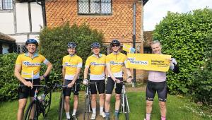 a group of people on bikes cheering in yellow cystic fibrosis trust tops