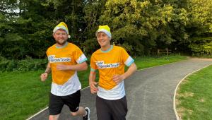 2 men running in cystic fibrosis trust yellow tops with yellow Santa hats